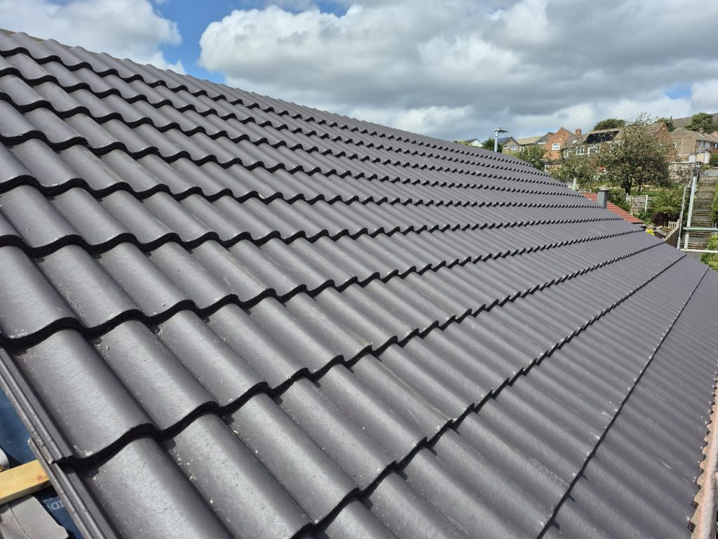 New grey concrete interlocking roof tiles installed on residential property in Leeds with dry ridge system