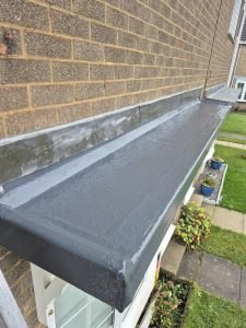 New grey GRP fibreglass flat roof installation on porch canopy with lead flashing at Leeds residential property
