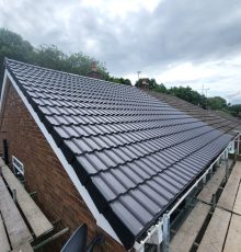 White fascia boards being fitted on moss-covered roof in Leeds